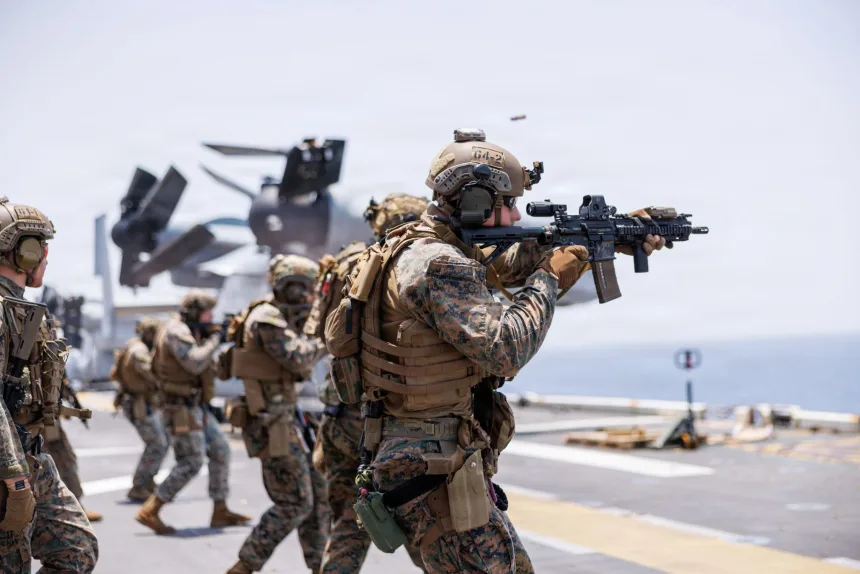U.S. Marines fire rifles during a deck shoot aboard the forward-deployed amphibious assault ship USS Tripoli, in the U.S. Central Command area of responsibility during Operation Epic Fury, on April 2. U.S. Central Command Public Affairs
